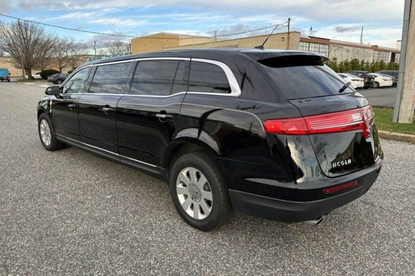A black SUV parked on a gravel surface with a clear sky in the background. 2