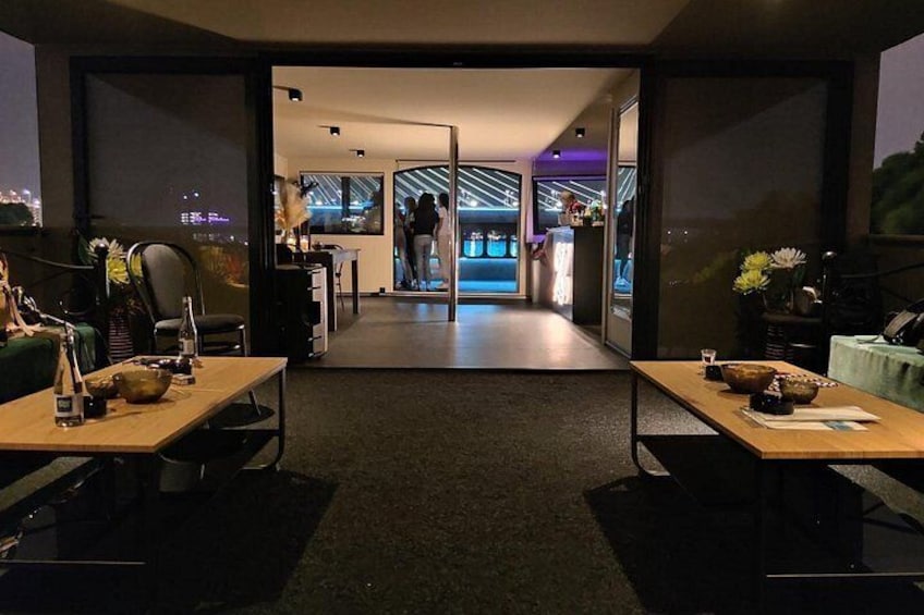A modern interior with a bar area, seating, and a view of the cityscape. 3