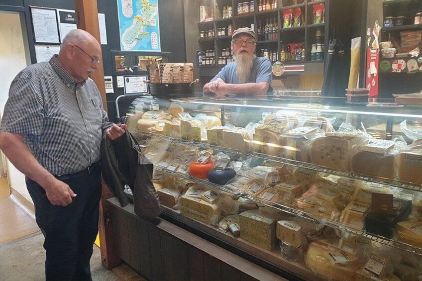 Exhibición de quesos en una tienda, con distintos tipos sobre estantes. 4