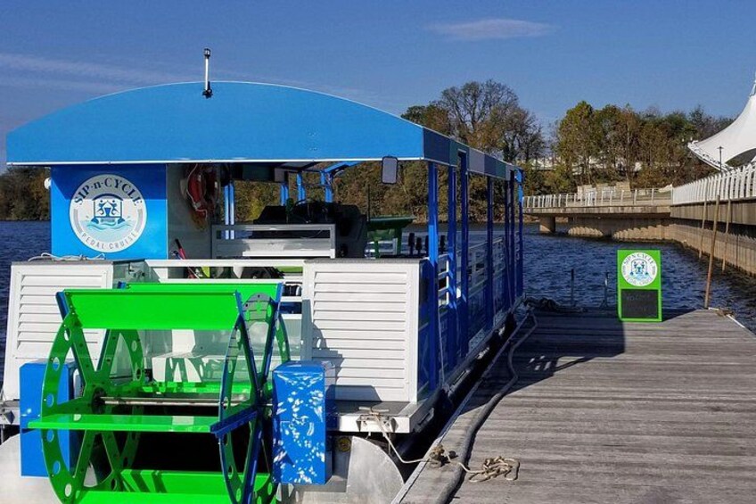 A blue and white boat with a green chair and a sign on a dock. 3