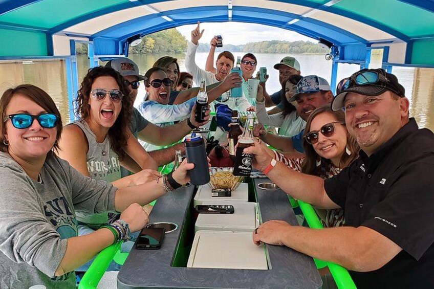 A group of people on a boat, toasting with drinks. 4