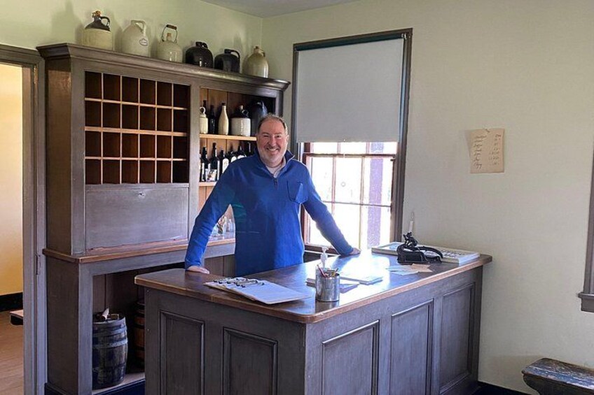 A person standing at a wooden counter with a window behind them. 2