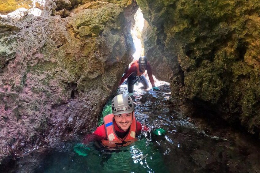 Dos personas en una cueva rocosa con agua. 4