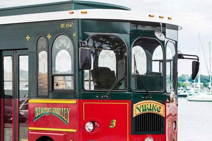 Un tranvía antiguo con la marca 'Newport Trolley' y 'Viking', estacionado junto a la costa. 3