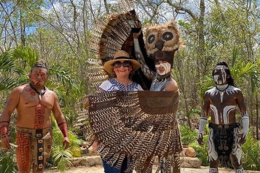 A person in a large animal costume, another in traditional attire, and a third in a patterned outfit. 4
