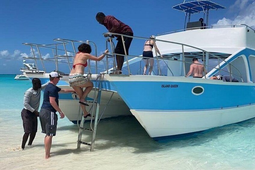 A boat named 'Island Queen' on a sandy beach with clear turquoise water. 1