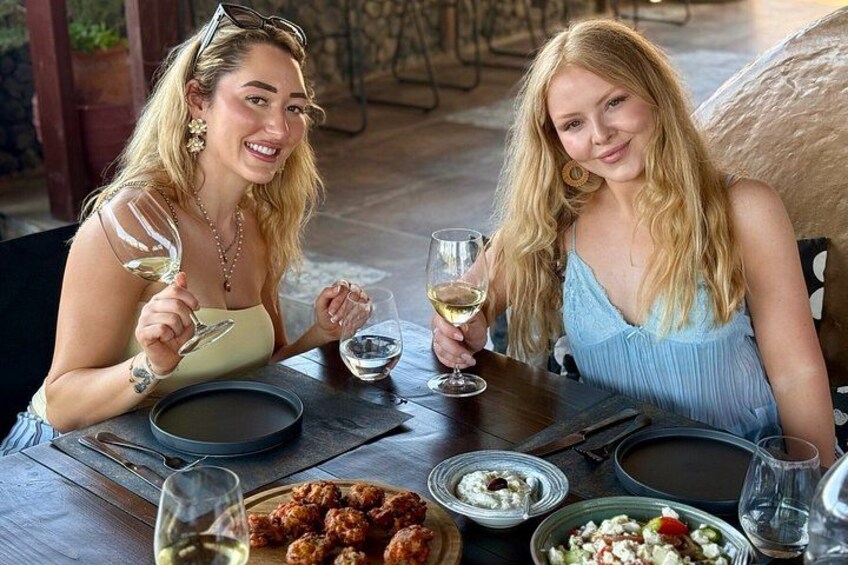 Zwei Personen essen in einem Restaurant im Freien. Der Tisch ist für eine Mahlzeit gedeckt, mit Speisen und Weingläsern. 3