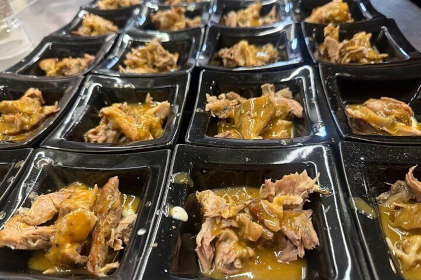 A tray of food containers with meat and sauce. 4