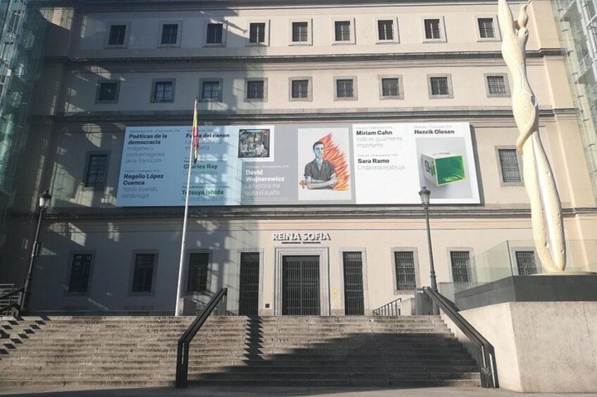 A building with multiple banners and a staircase leading to the entrance. 2