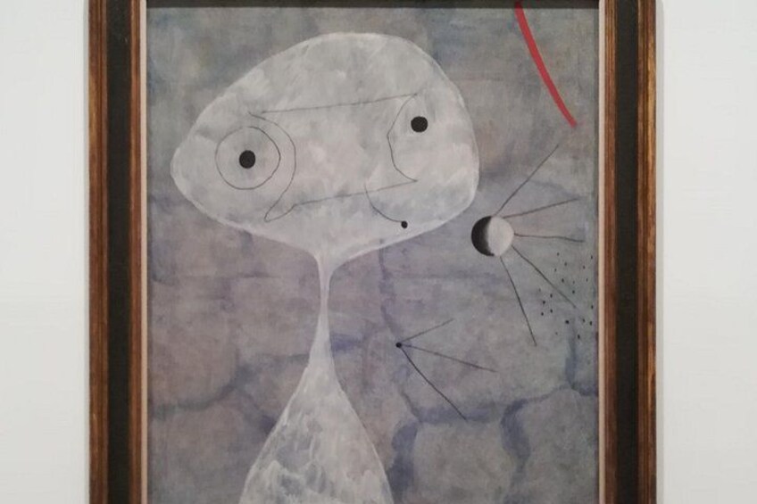 Un cuadro abstracto enmarcado con un rostro estilizado, una línea curva roja y un pequeño objeto similar a una luna. 2