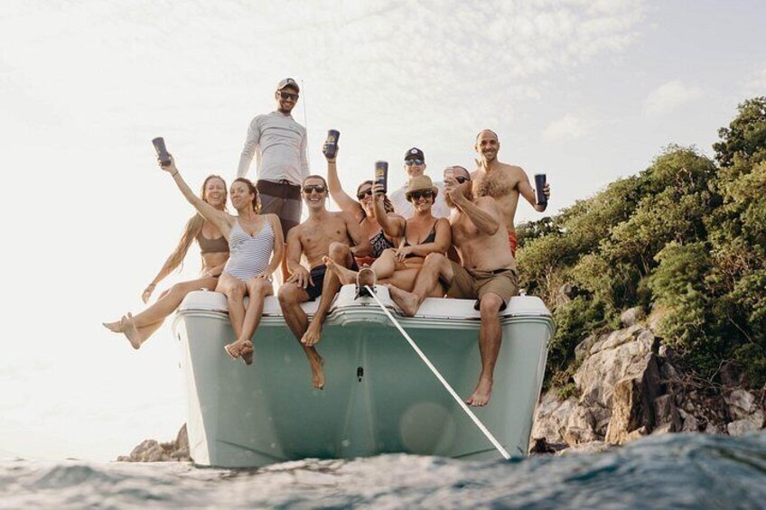 Un groupe de personnes se trouve sur un bateau, au milieu d’une étendue d’eau, entouré de verdure. 3