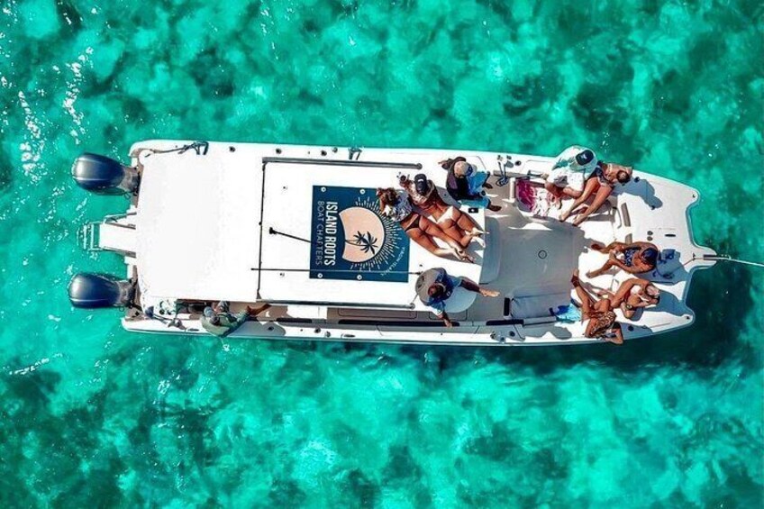 Un bateau blanc orné d’un logo à l’arrière, entouré d’une eau turquoise et cristalline. 2