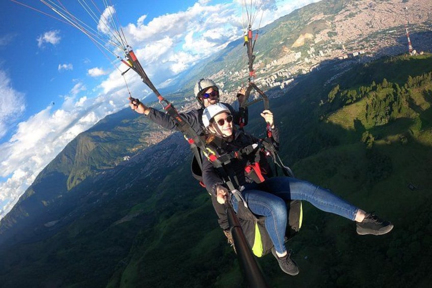 Eine Person macht Gleitschirmflug mit einer bergigen Landschaft im Hintergrund. 1