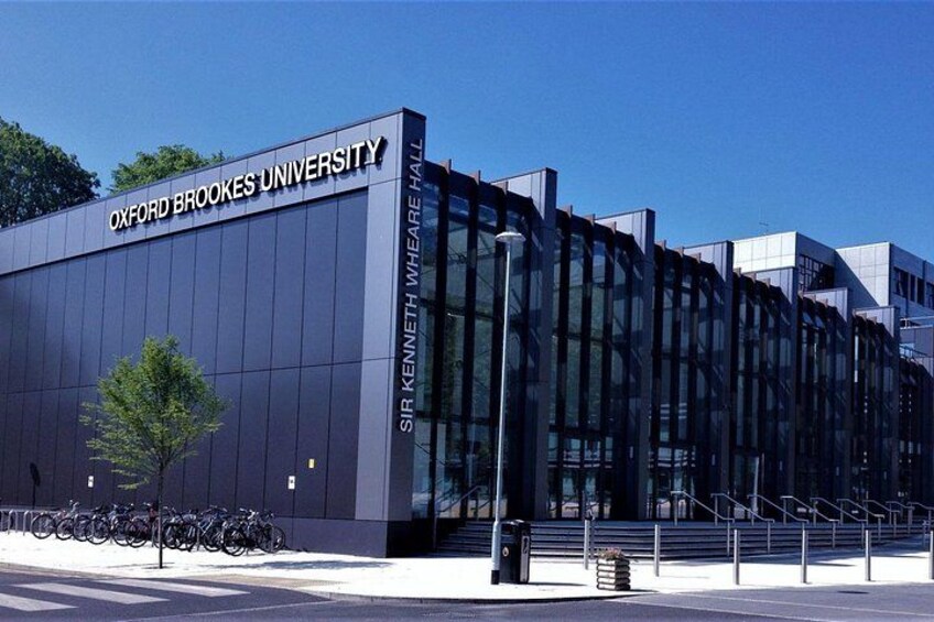 Oxford Brookes University building, Sir Kenneth Whelan Hall, with a modern glass facade and a tree in front. 2