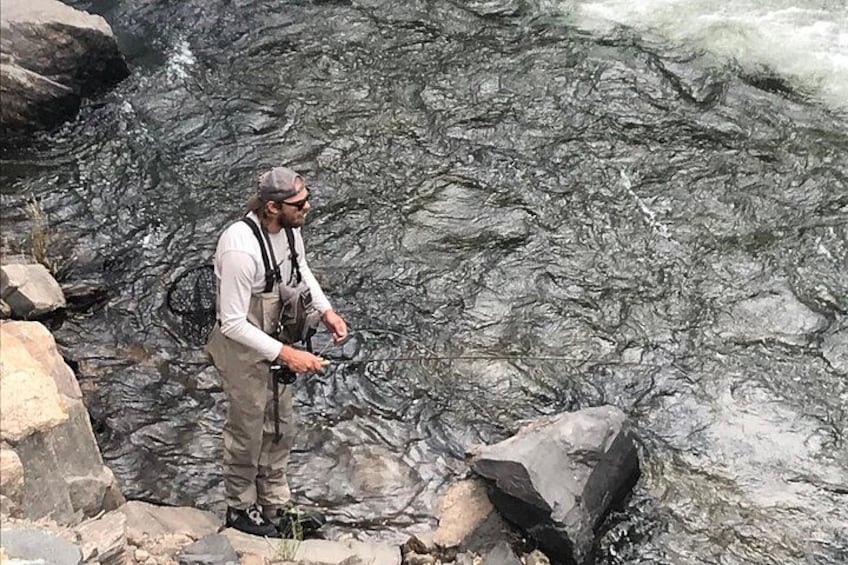 A person fishing in a rocky stream. 3