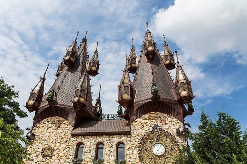 A castle with multiple pointed towers and a clock on its facade. 3