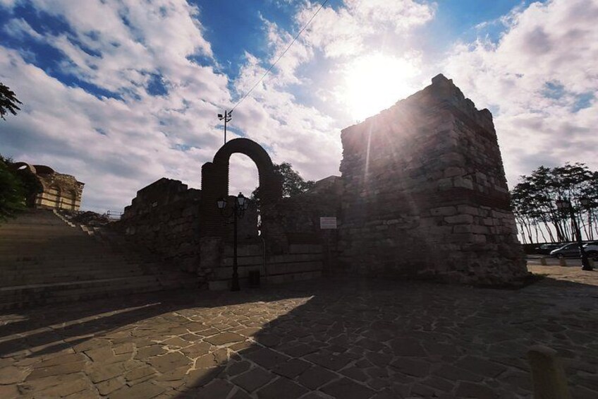 Antiche rovine in pietra con un arco, sotto un cielo parzialmente nuvoloso. 3
