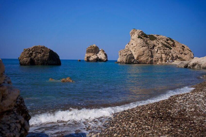 A rocky shoreline with clear blue water and large boulders. 3