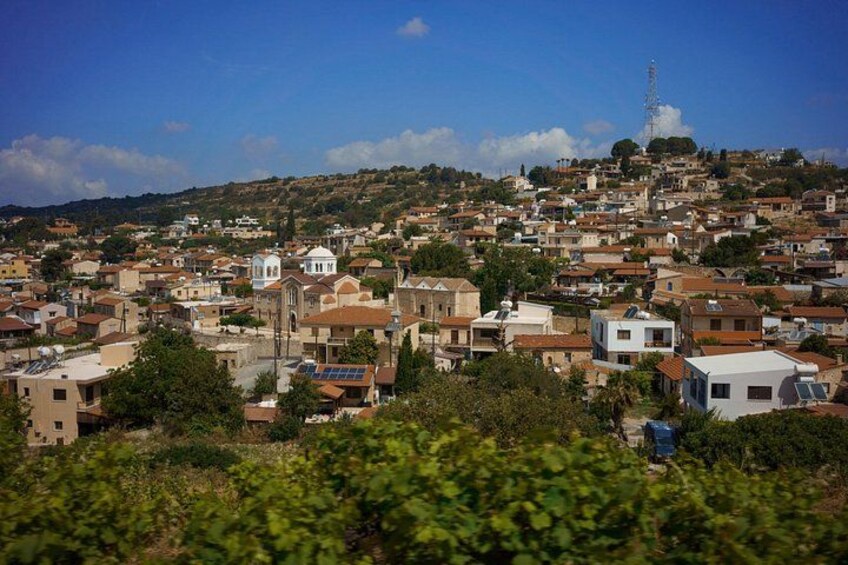 A densely packed hillside town with buildings, a church, and a tower. 2
