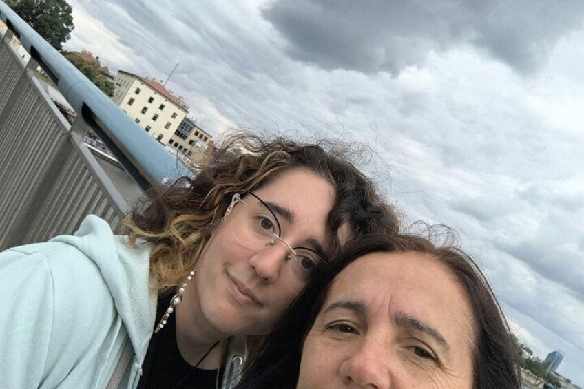Deux personnes sur un toit, avec un ciel nuageux et des bâtiments en arrière-plan. 3
