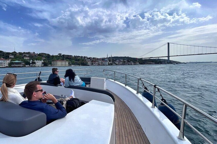 Un bateau avec des personnes sur le pont, un pont en arrière-plan et une étendue d’eau. 5