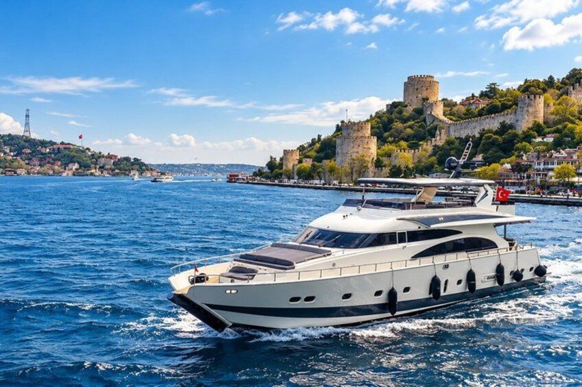 Un yacht blanc sur une étendue d’eau bleue, avec un château perché sur une colline en arrière-plan. 4