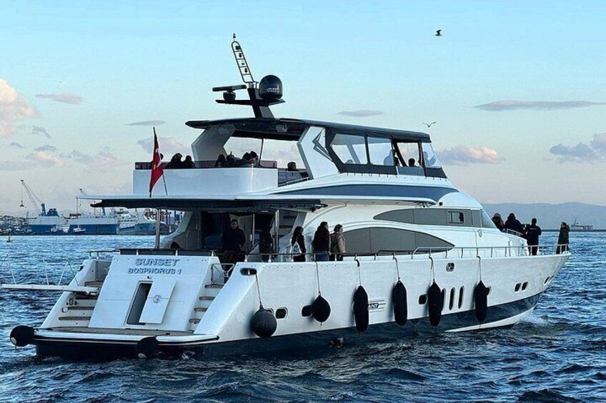A white boat with multiple decks and passengers, sailing on the water. 2