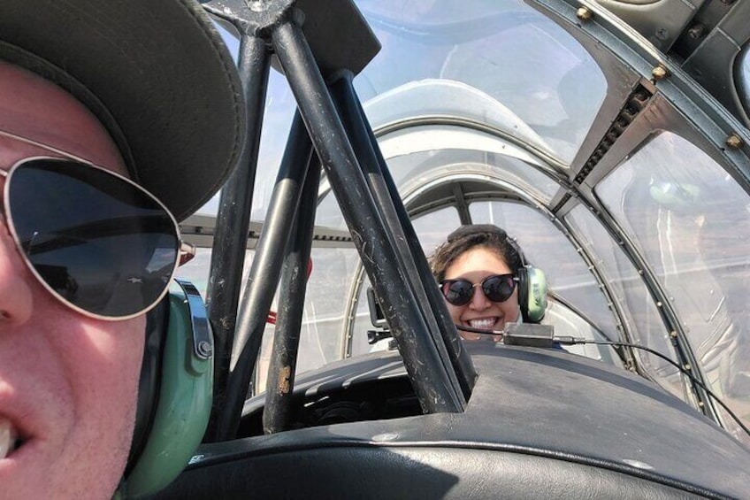 Een persoon met vliegeniershelm in het cockpit van een vliegtuig. 4