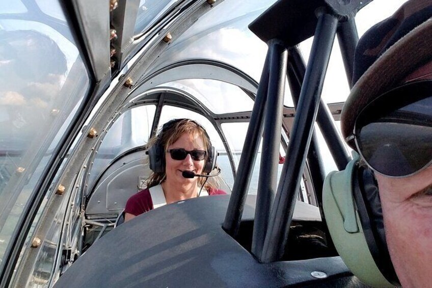 Iemand in een cabine met een headset, een bedieningspaneel en een raam. 2