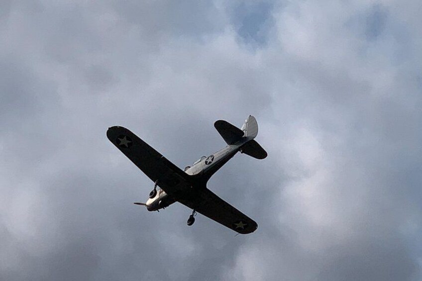 A vintage military aircraft flying against a cloudy sky. 3