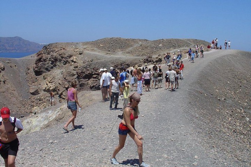 A group of people walking on a rocky path with a mountainous landscape in the background. 3