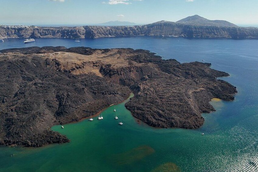 A volcanic island with a clear blue sea, surrounded by mountains. 3