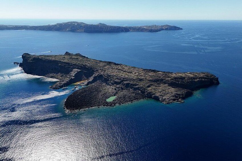 A rugged island with a rocky coastline and clear blue waters. 2