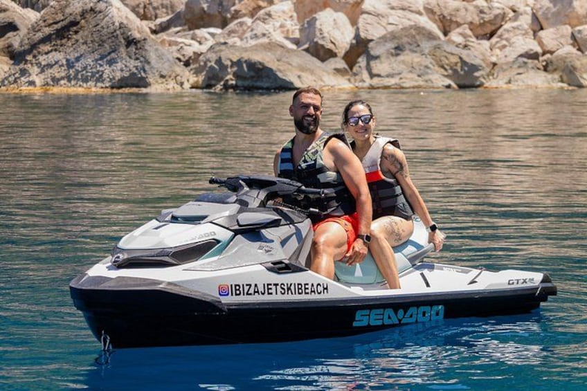 Ein Jetski auf ruhigem Wasser, im Hintergrund eine felsige Küste. 2
