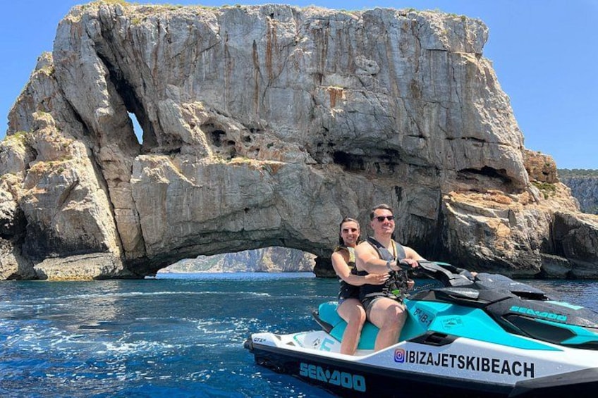 Ein Jetski mit zwei Personen, eine felsige Felsklippe und klares, blaues Wasser. 4