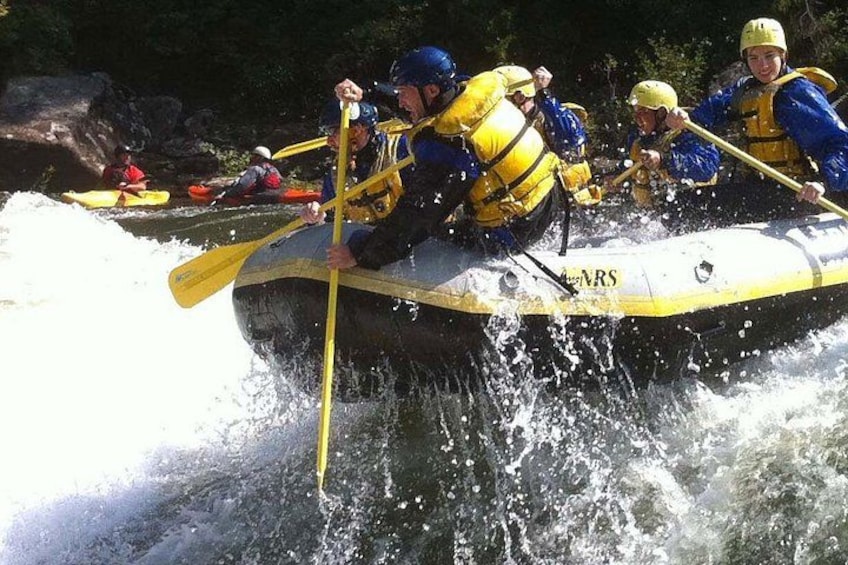 Un groupe de personnes à bord d’un radeau qui descend une rivière en franchissant des rapides. 2