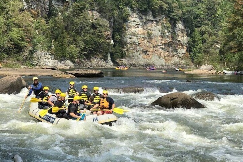 Een groep mensen die over een rivier raften, omringd door rotsachtige kliffen. 5