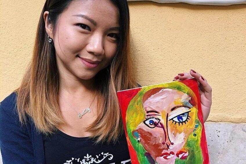 A person holding a colorful painting. 2