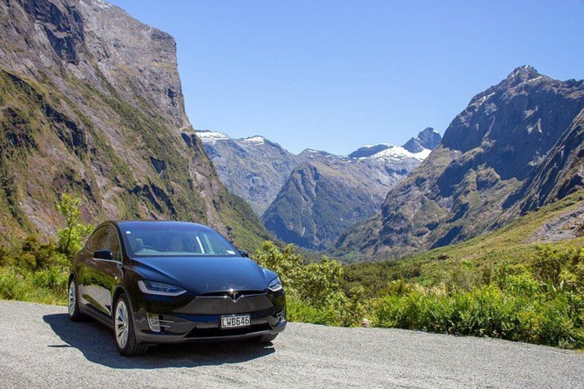 A car parked on a road with a mountainous landscape in the background. 2