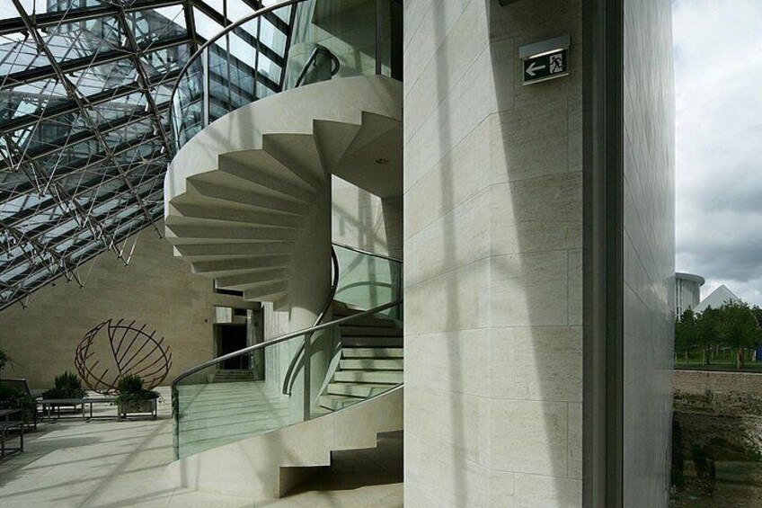 A spiral staircase inside a building with a glass ceiling. 3
