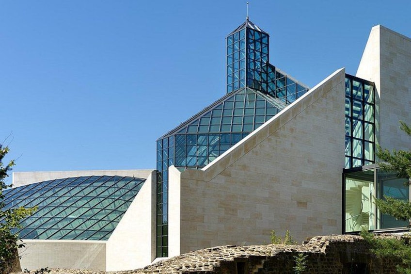 A modern building with a glass facade and a unique geometric design. 4