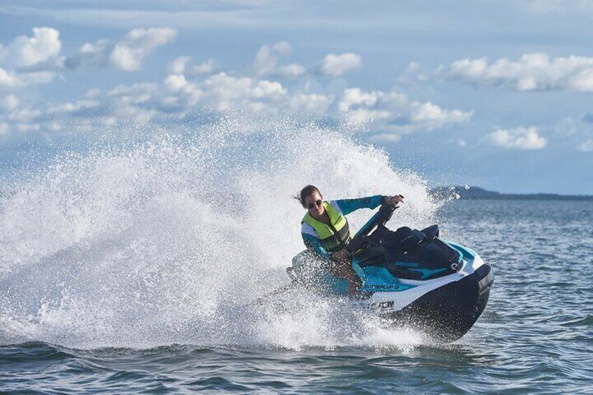 Una persona conduciendo un jet ski sobre el agua, con salpicaduras a su alrededor. 5