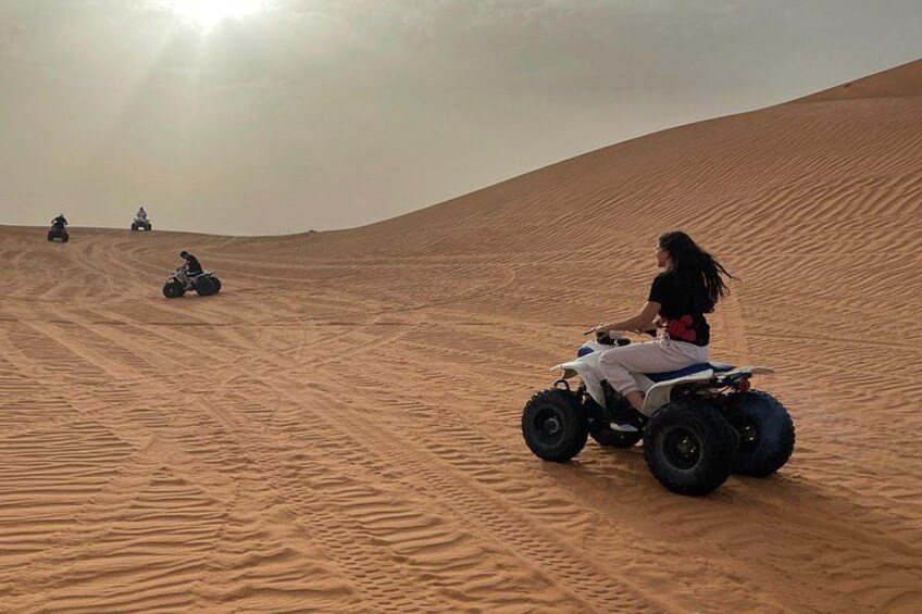 A desert landscape with sand dunes and a person riding an ATV. 5