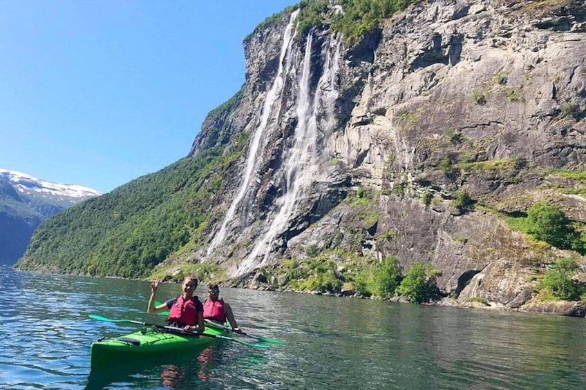 Een kajak op kalm water, met een waterval op de achtergrond. 3
