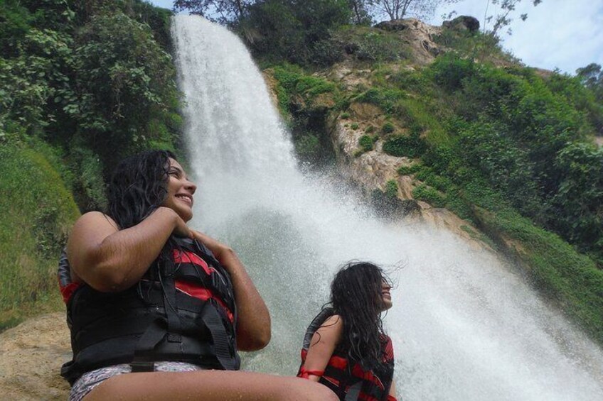 Two people sitting near a waterfall. 5