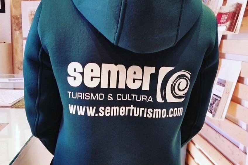 Une personne portant un sweat à capuche sur lequel est inscrit le texte « Semer Turismo & Cultura » et une adresse de site web. 4