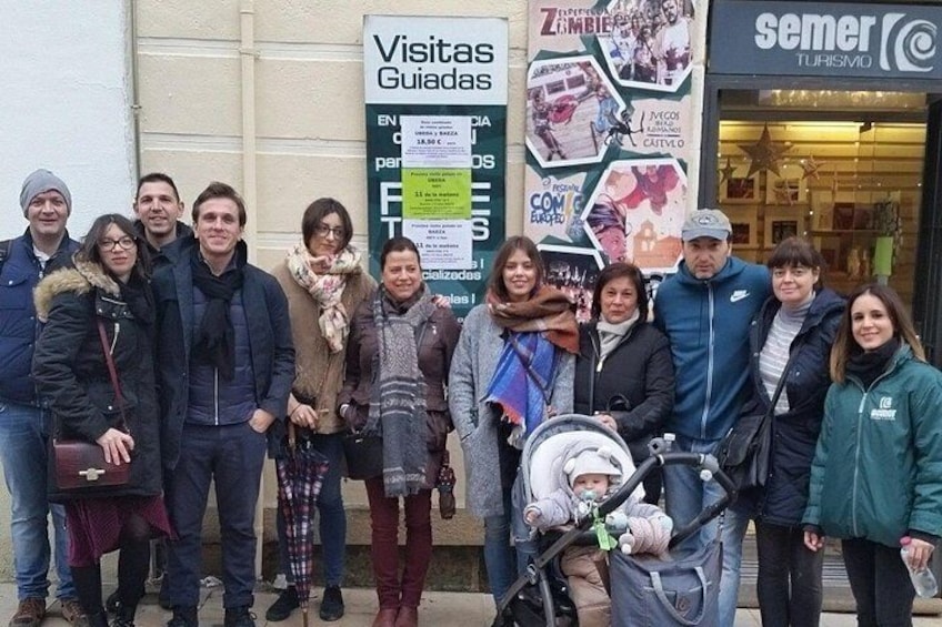 Un groupe de personnes se tient devant un bâtiment sur lequel est apposée une pancarte indiquant « Visites guidées ». 3