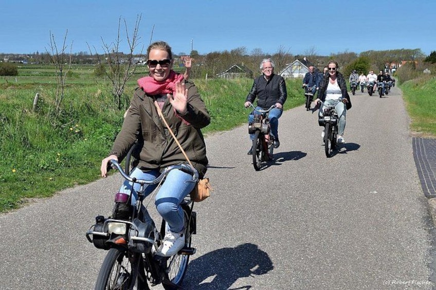 People riding bicycles on a paved path surrounded by greenery. 5