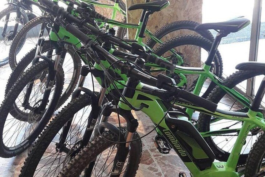 A row of green mountain bikes with black tires and black seats. 3