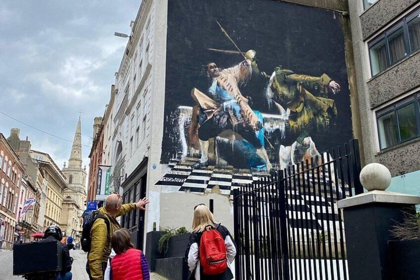 A mural of a knight on horseback on a city street. 3